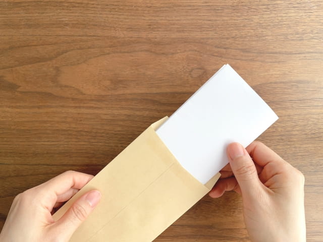 白い封筒を手渡す様子